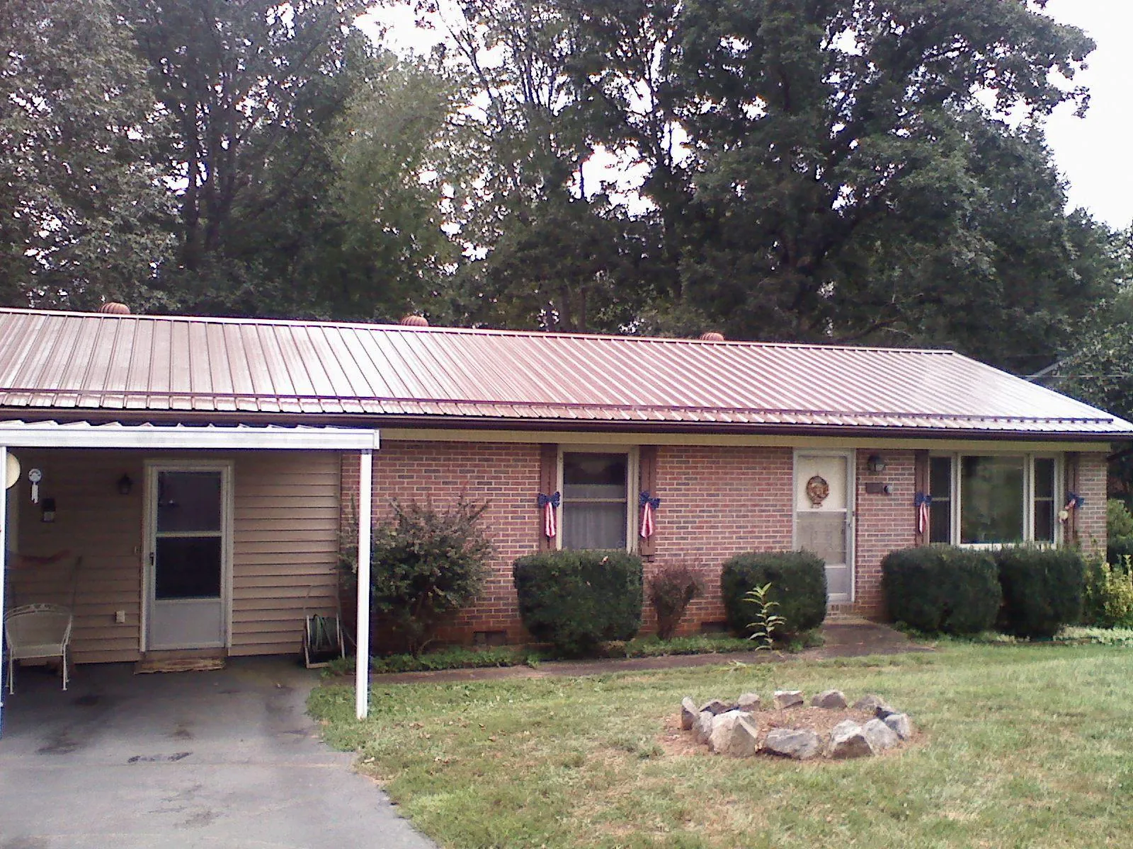 Bronze metal roof and carport on a brick ranch home — Roof Repair work by our crew in Lower Salem